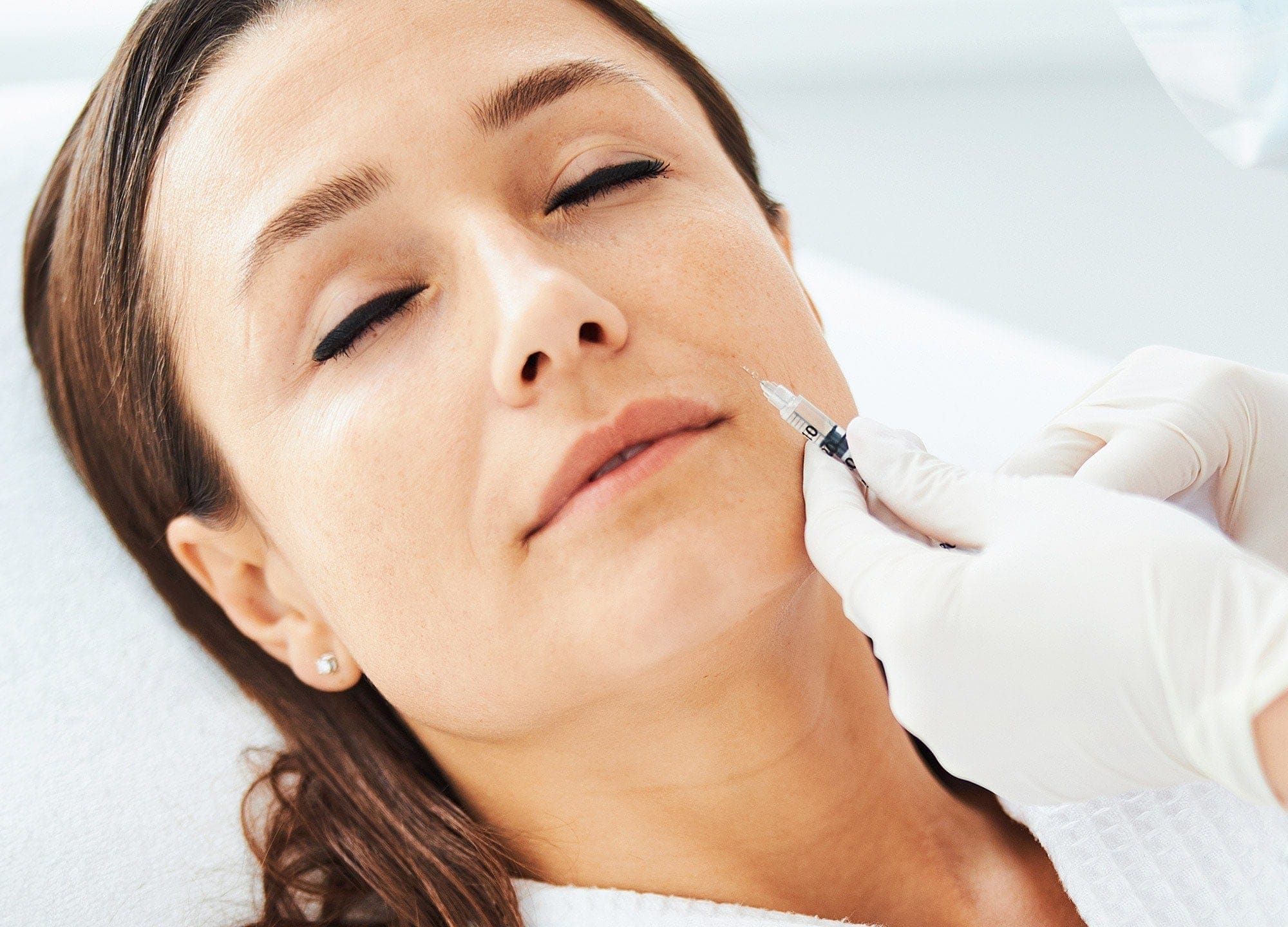 Woman receiving filler to soften nasolabial folds and smile lines in Oakville