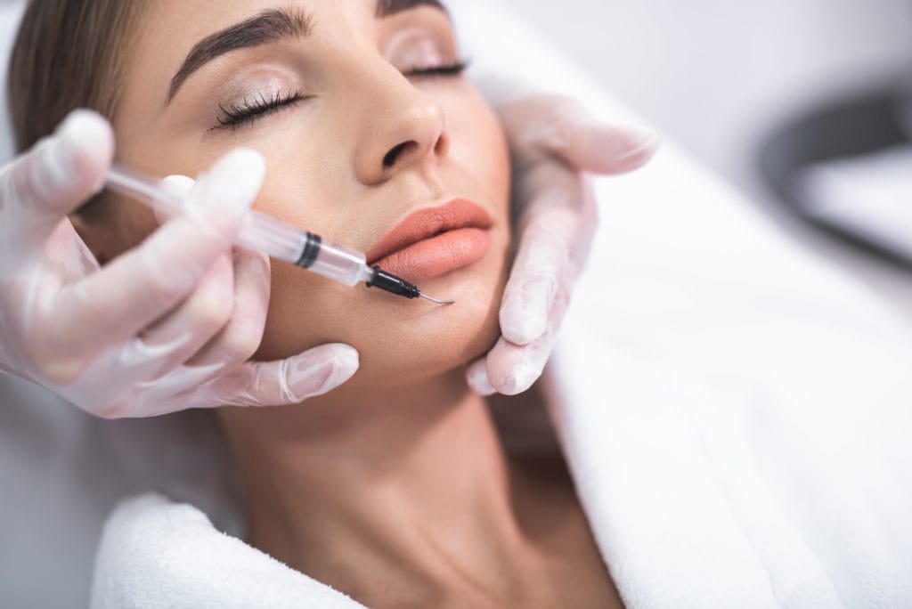 Woman receiving chin filler to improve chin projection and profile in Oakville