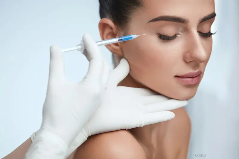 Advanced aesthetic nurse injector planning a facial balancing treatment at Oakville Flawless Cosmetic