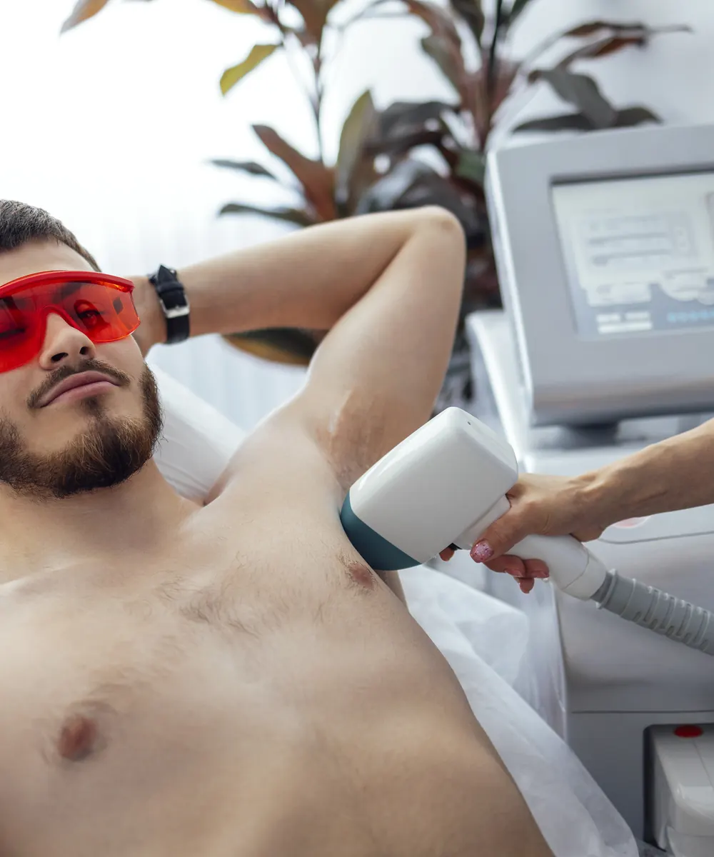 Man receiving laser hair removal treatment at a beauty clinic