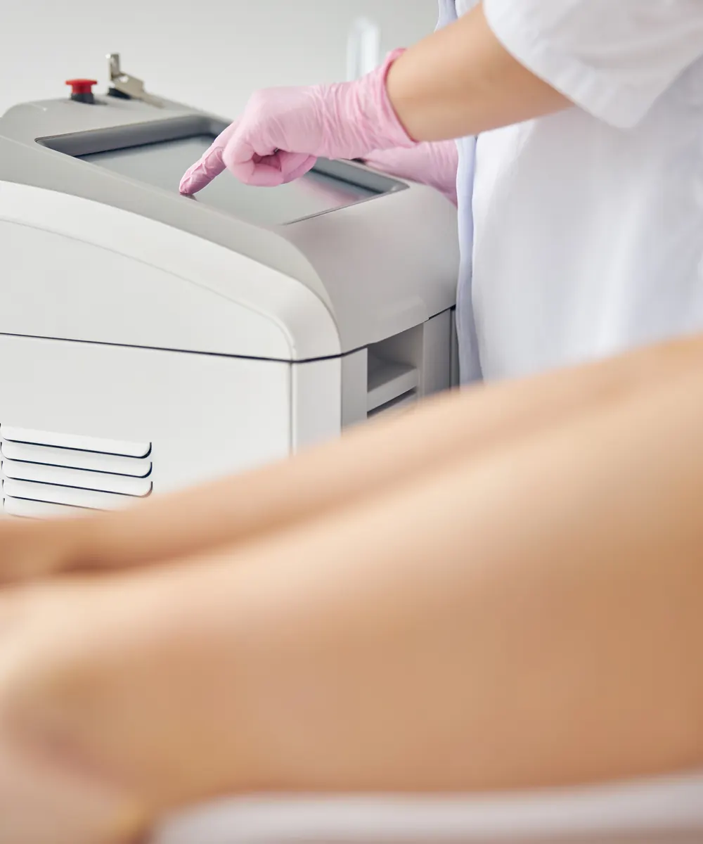 Technician operating a laser hair removal machine in a treatment room