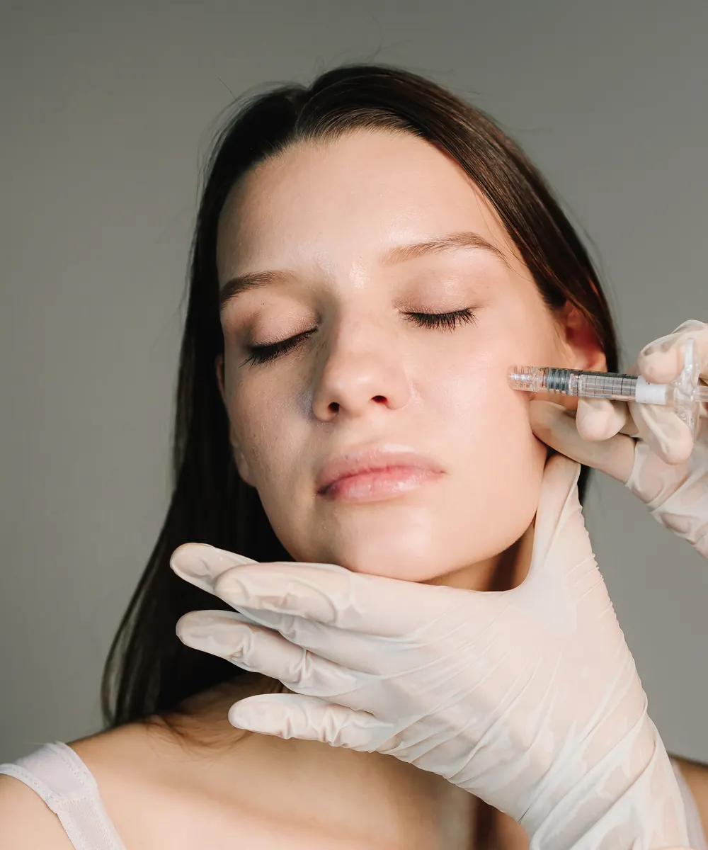 Clear injectable gel and a syringe laid out on a sterile clinic tray