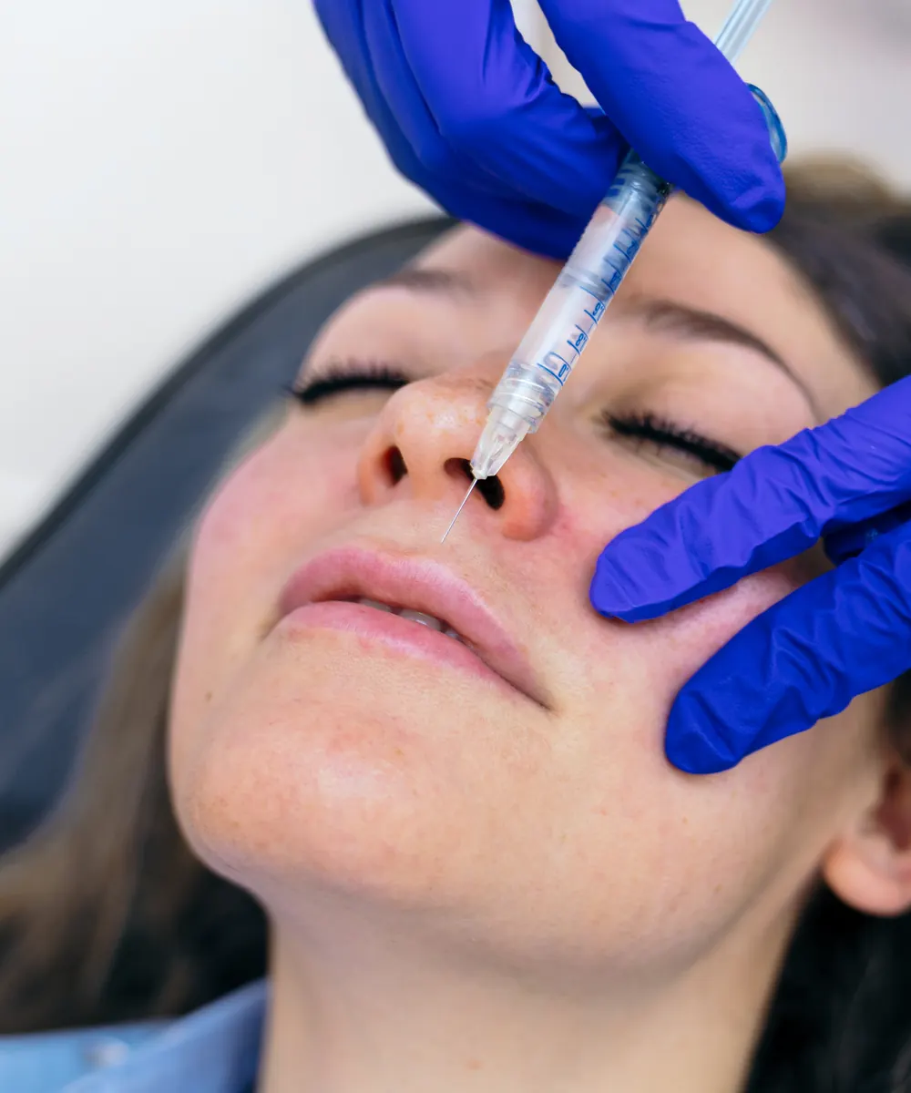 Practitioner carrying out an injectable cosmetic procedure on a patient in a clinic